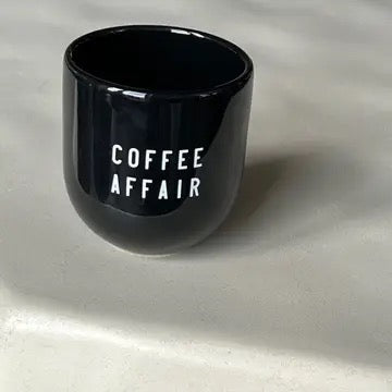 Becher mit Aufschrift in schwarz