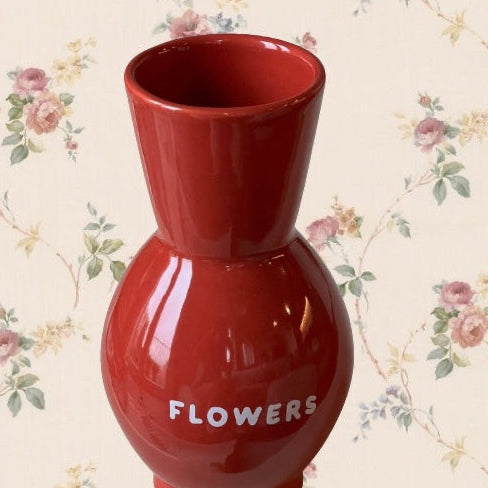 Rote Vase mit Aufschrift flowers